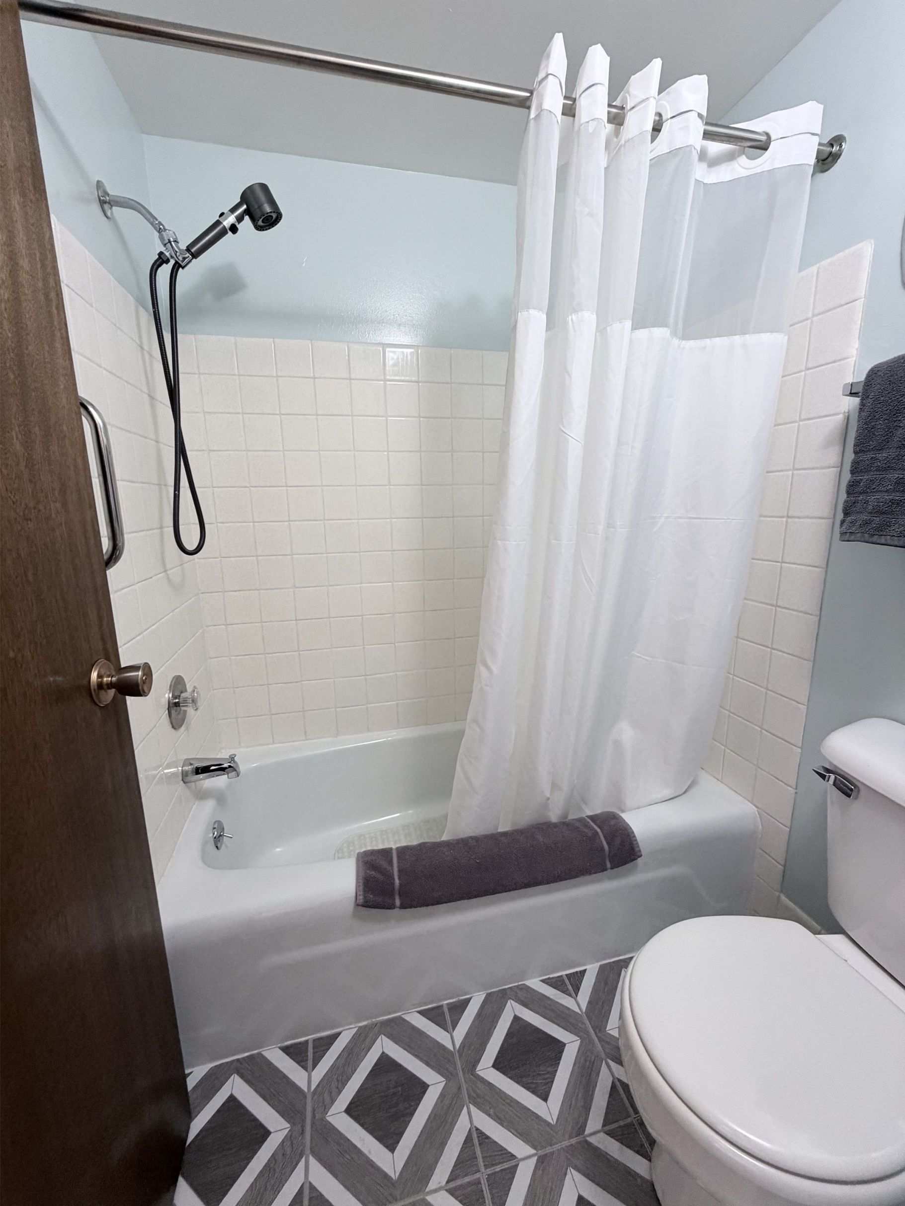 Clean private guest bathroom with tub and shower