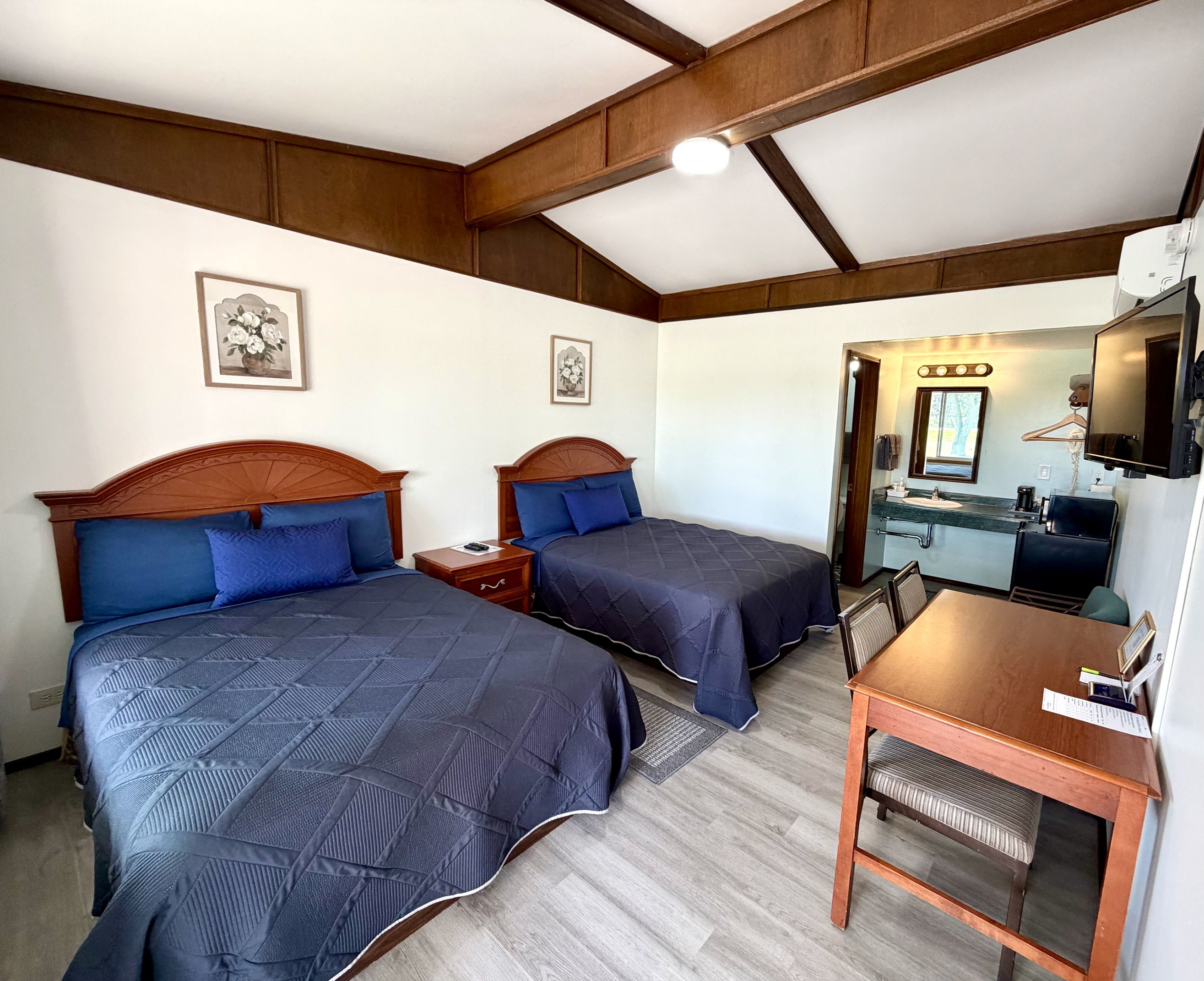Double room with two double beds, work table, and vanity area