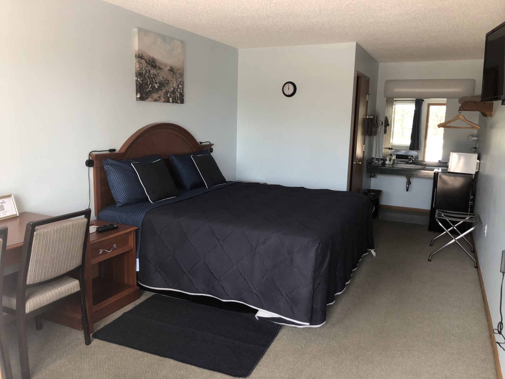 King room with a king bed, desk, and vanity area